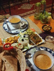 a table with plates of food on a table at Azadic luxury tents in Merzouga