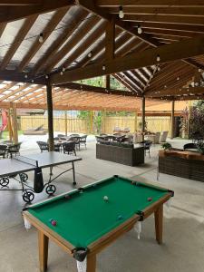a pool table in a patio with tables and chairs at Gaia Hotelaria in Teresópolis