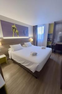 a bedroom with a large white bed in a room at Best Western Hotelio Montpellier Sud in Montpellier