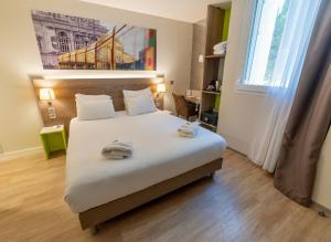 a bedroom with a bed with two towels on it at Best Western Hotelio Montpellier Sud in Montpellier