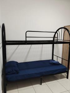 a black bunk bed with a blue mattress on it at IJM Suria Homestay in Sandakan