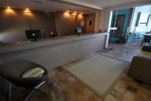 a lobby with a bar with a couch and chairs at Pousada Caravelas de Pinzón in Cabo de Santo Agostinho