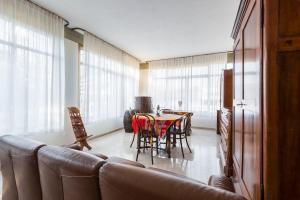 a living room with a couch and a table with chairs at Il Melograno, appartamento privato in Cavriago