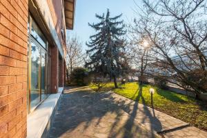 a walkway next to a brick building with a tree at Il Melograno, appartamento privato in Cavriago