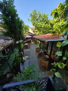 an outdoor patio with tables and chairs and trees at Pousada Casa Rosa in Itacaré
