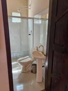 a bathroom with a toilet and a sink at Pousada Casa Rosa in Itacaré