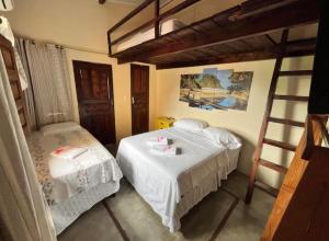 a bedroom with two beds and a ladder at Pousada Casa Rosa in Itacaré