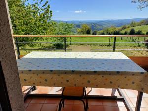 a table on a balcony with a view of a field at La Chambre du Bout du Monde in Bouillac +5 photos