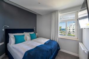 a bedroom with a blue and white bed and a window at Strandvilla Glückauf in Binz