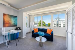 a living room with a blue couch and a table at Strandvilla Glückauf in Binz