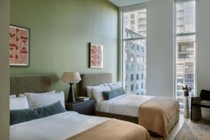 a hotel room with two beds and a window at ROOST Rainey in Austin +33 photos