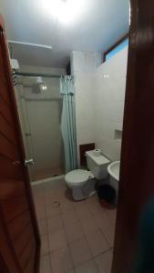 a bathroom with a toilet and a shower and a sink at Hotel La Tolita in Atacames