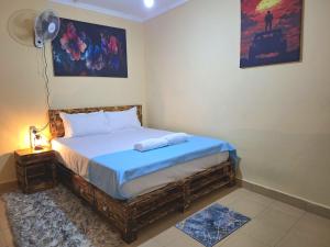a small bedroom with a bed with a blue blanket at Janari Homes in Diani Beach