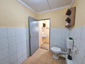 a bathroom with a toilet and a shower with a door at Janari Homes in Diani Beach +45 photos