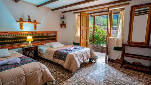 a bedroom with two beds and a fireplace at Casita Huaran in Calca
