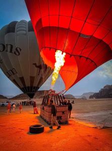 a group of hot air balloons being inflated at Wadi rum Rozana camp in Wadi Rum