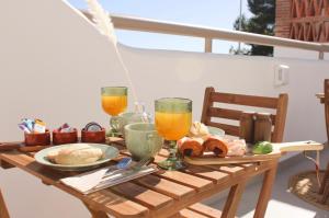 a wooden table with food and two glasses of orange juice at HA Hotel TESORO MEDITERRANEO in Almuñécar