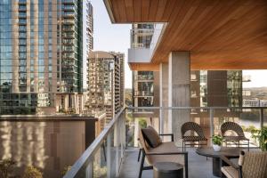 a balcony with chairs and a table and some buildings at ROOST Rainey in Austin