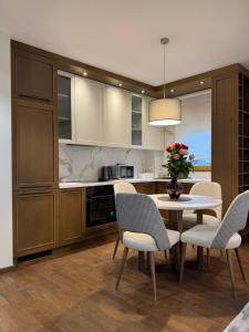 a kitchen with a table and chairs and a vase with flowers at Tilia Lux Wellnes &Spa in Čačak