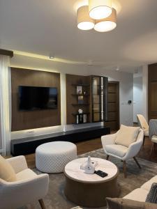 a living room with a couch and chairs and a tv at Tilia Lux Wellnes &Spa in Čačak
