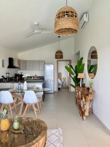 a kitchen and living room with a table and chairs at Villa Ar Mor - Oceanfront pool & Saint-Barth view Oyster pond in Saint Martin