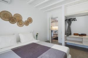 a bedroom with a bed and two mirrors on the wall at Mykonos Dunes Villas in Mikonos +118 photos