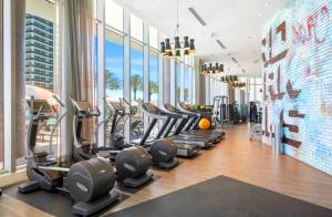 a gym with rows of treadmills and elliptical machines at Oceanfront Escape - Rooftop Pool & Beach Access in Hollywood