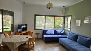 a living room with a blue couch and a table at Holiday home in Galilee in Sheʼar Yashuv