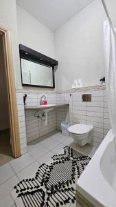 a bathroom with a toilet and a black and white rug at Holiday home in Galilee in Sheʼar Yashuv +34 photos