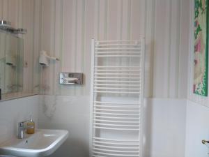 a bathroom with a sink and a white towel rack at Privatpension Waldbröl in Waldbröl +24 photos