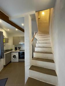 a staircase in a kitchen next to a kitchen with a stove at la terrasse in Marseillan