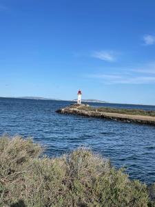 a lighthouse on an island in the water at la terrasse in Marseillan +3 photos