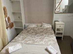 a small bedroom with a bed and a night stand at la terrasse in Marseillan