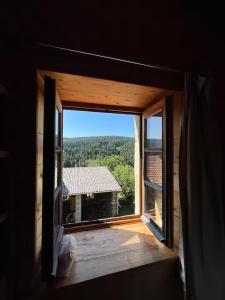 an open window with a view of a house at Chambre de charme in Berbezit +5 photos