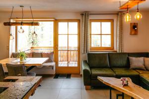 a living room with a couch and a table at Bauernhofurlaub Eggcellence in Teisendorf