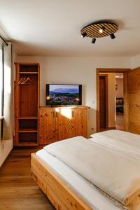 a bedroom with a bed and a flat screen tv at Bauernhofurlaub Eggcellence in Teisendorf