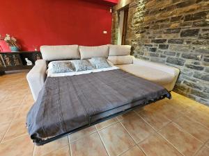a large bed in a room with a brick wall at Casa Martín in Guaso