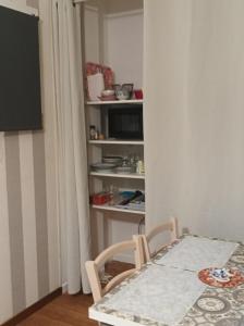 a table and chairs in a room with a tv at Le nid de mésanges in Chauffour-sur-Vell