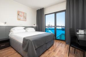 a bedroom with a bed and a large window with a view at Hotel Tammsaare Full Automated Hotel in Pärnu +37 photos
