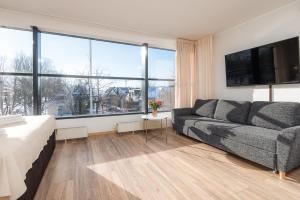 a living room with a couch and a large window at Hotel Tammsaare Full Automated Hotel in Pärnu