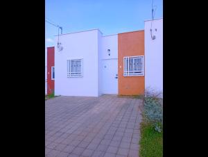 a building with white doors and a brick driveway at Casa de Milo in Ahuachapán