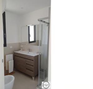 a bathroom with a shower and a sink and a mirror at Oris in Oristano