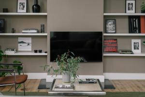 a living room with a table and a tv at A Place Antwerp - Boutique Suites & Flats - Schuttershofstraat 1 in Antwerp