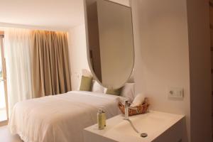 a bedroom with a bed with a mirror and a sink at HA Hotel TESORO MEDITERRANEO in Almuñécar