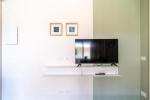 a living room with a tv on a white wall at Penelope al mare 6 in Alba Adriatica