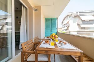 a wooden table with a plate of food on a balcony at Penelope al mare 6 in Alba Adriatica