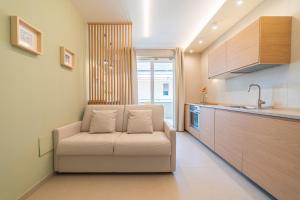 a living room with a white couch in a kitchen at Penelope al mare 6 in Alba Adriatica +26 photos