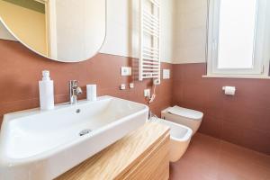 a bathroom with a sink and a toilet and a mirror at Penelope al mare 6 in Alba Adriatica
