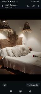 a bedroom with a white bed with two lights at El rincón del Vadillo in La Velilla