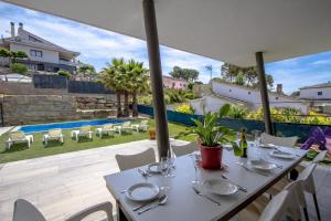 a dining table with white chairs and a view of a pool at Catalunya Casas Modern Marvel,15 min to Costa Brava beaches! in Sils